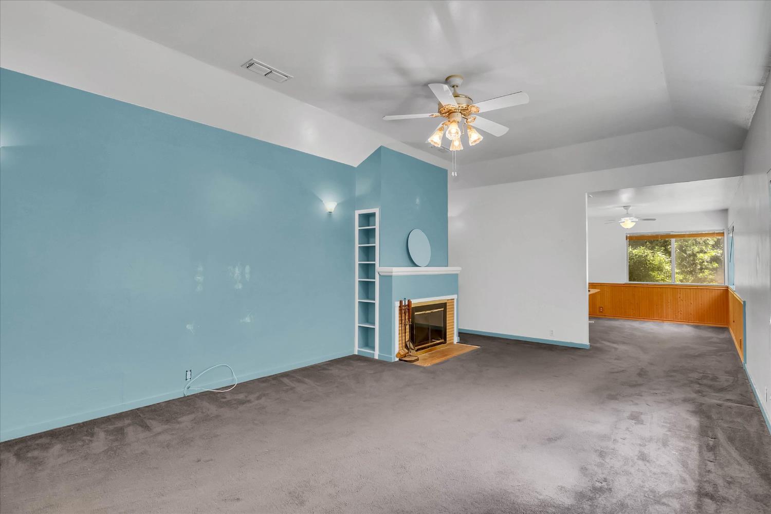 39640 South River Road Clarksburg, CA 95612 - Photo 5 of 25 an empty room with a fireplace and chandelier fan