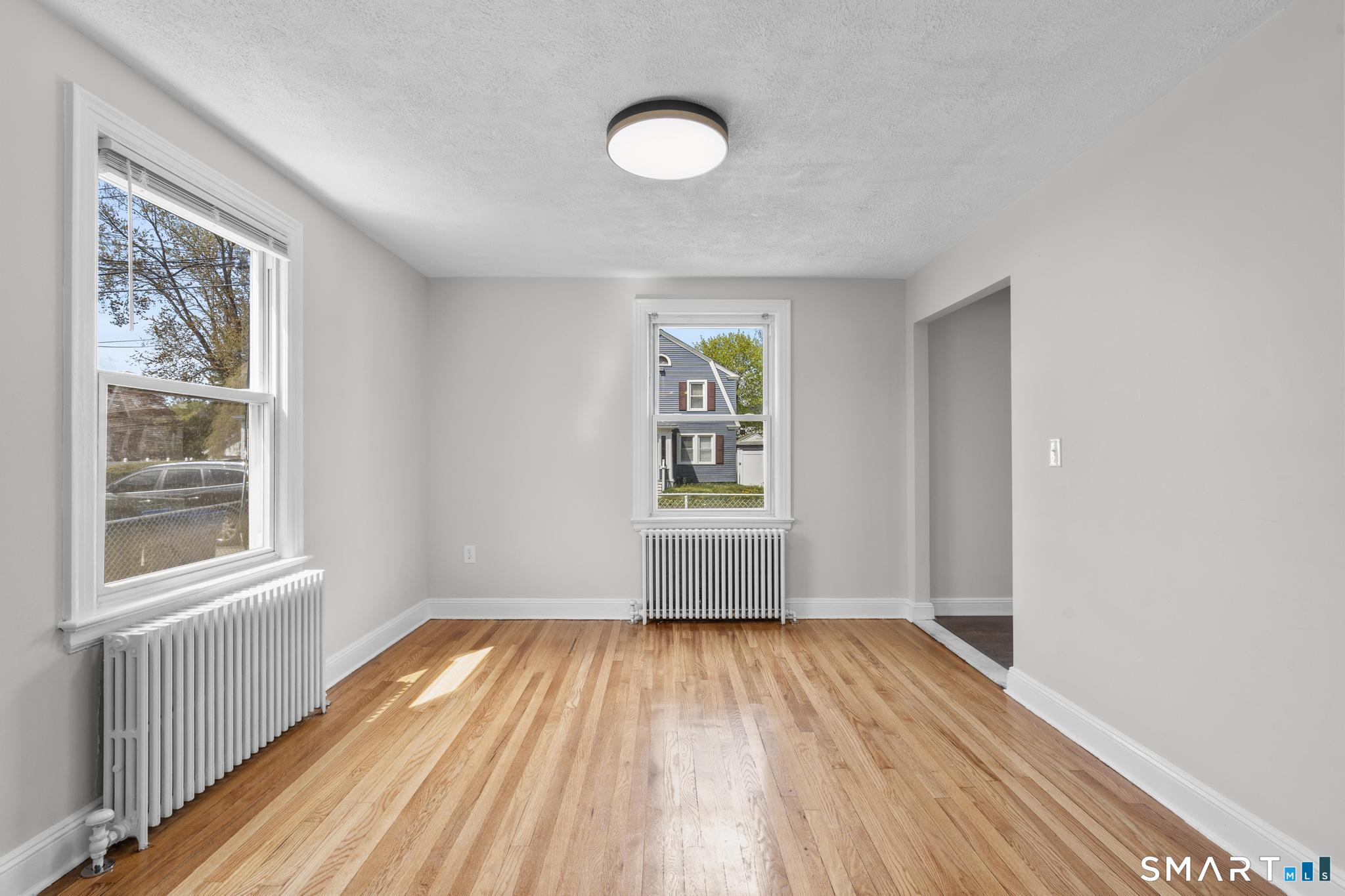 94 3rd Street Hamden, CT 06514 - Photo 12 of 30 a view of empty room with wooden floor and fan
