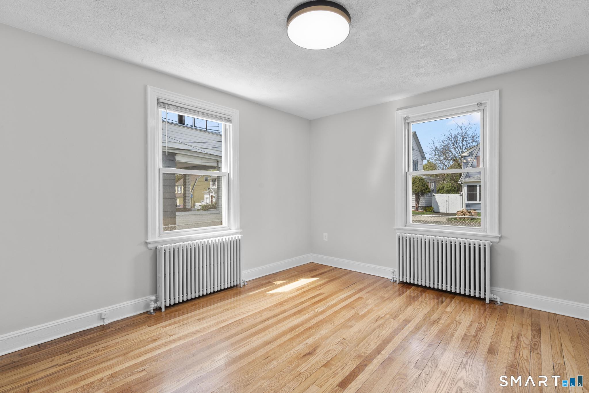 94 3rd Street Hamden, CT 06514 - Photo 14 of 30 an empty room with wooden floor and windows
