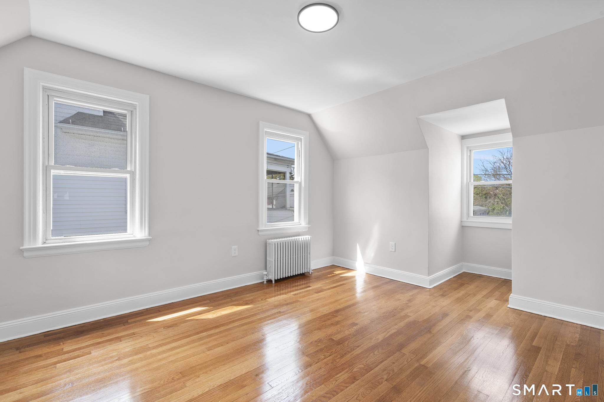 94 3rd Street Hamden, CT 06514 - Photo 17 of 30 an empty room with wooden floor and windows