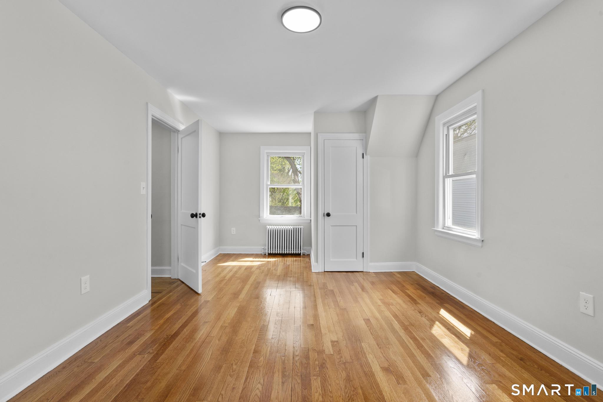94 3rd Street Hamden, CT 06514 - Photo 18 of 30 a view of empty room with wooden floor and fan