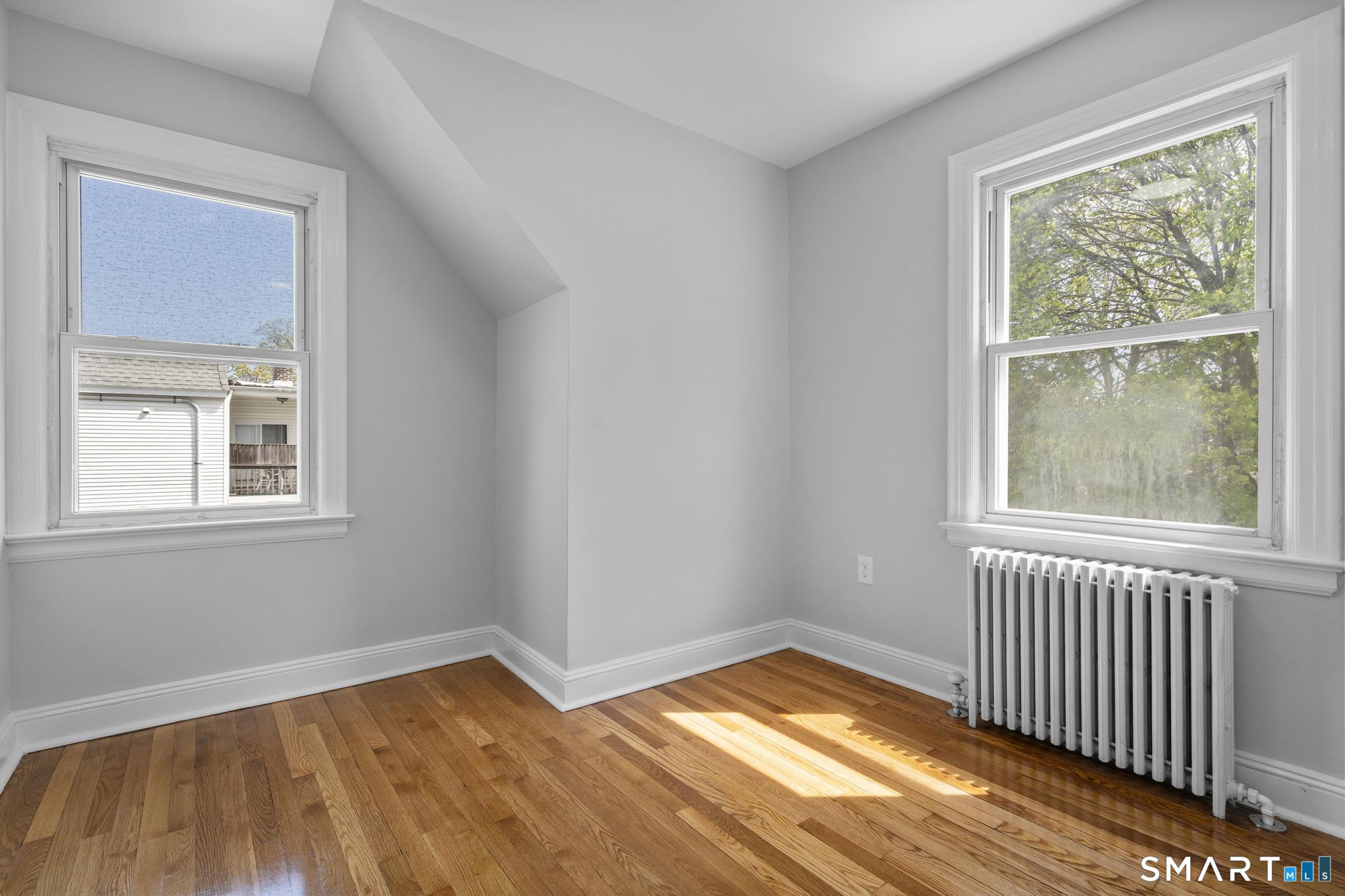 94 3rd Street Hamden, CT 06514 - Photo 20 of 30 a view of empty room with wooden floor and fan