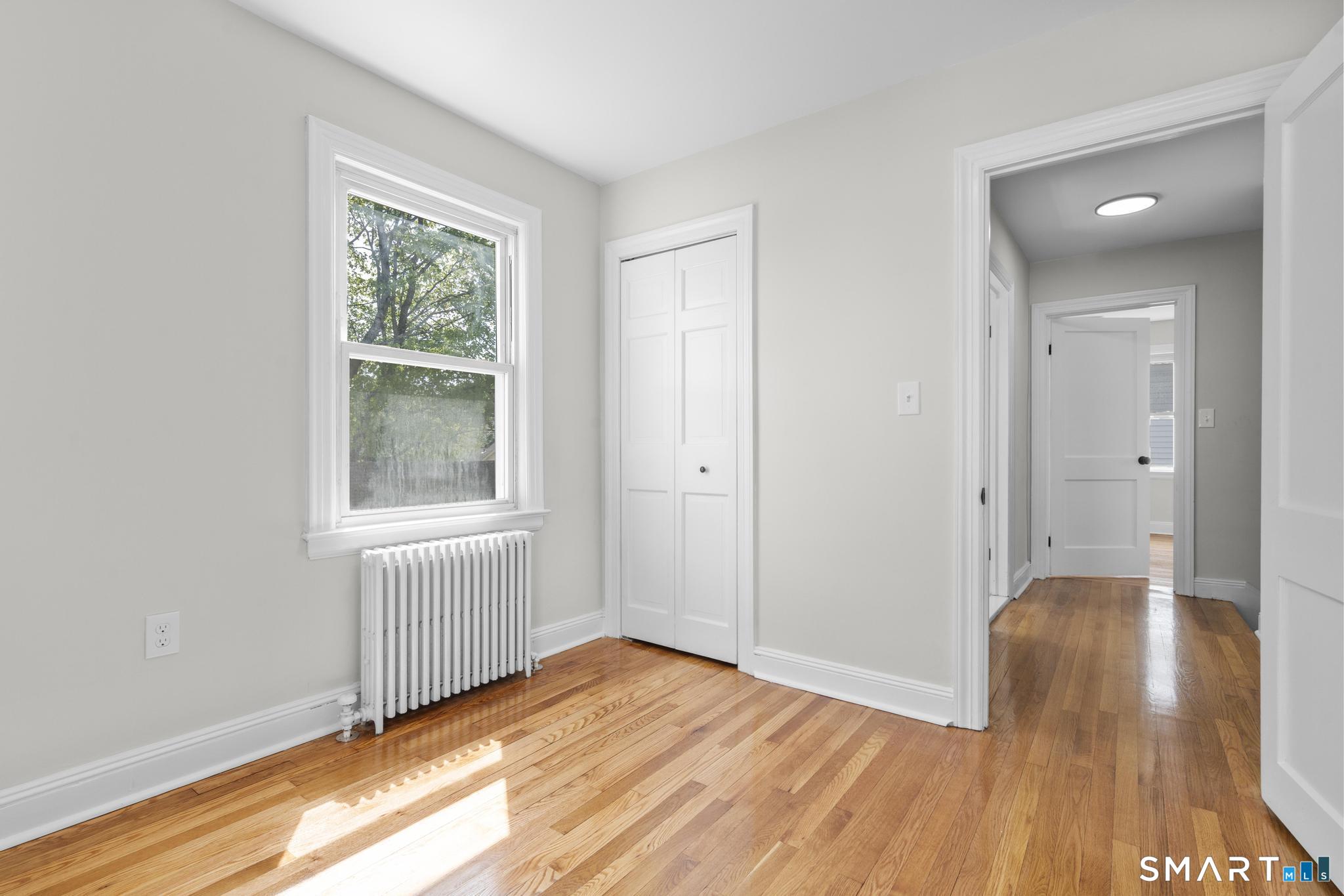 94 3rd Street Hamden, CT 06514 - Photo 21 of 30 an empty room with wooden floor and windows