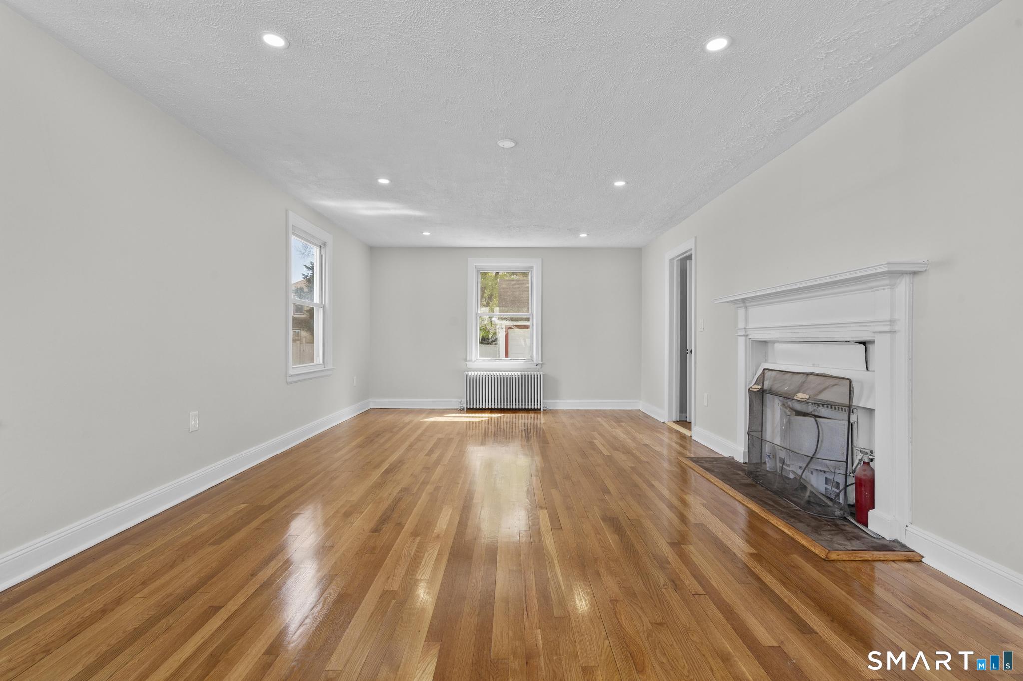 94 3rd Street Hamden, CT 06514 - Photo 6 of 30 a view of empty room with wooden floor and fan
