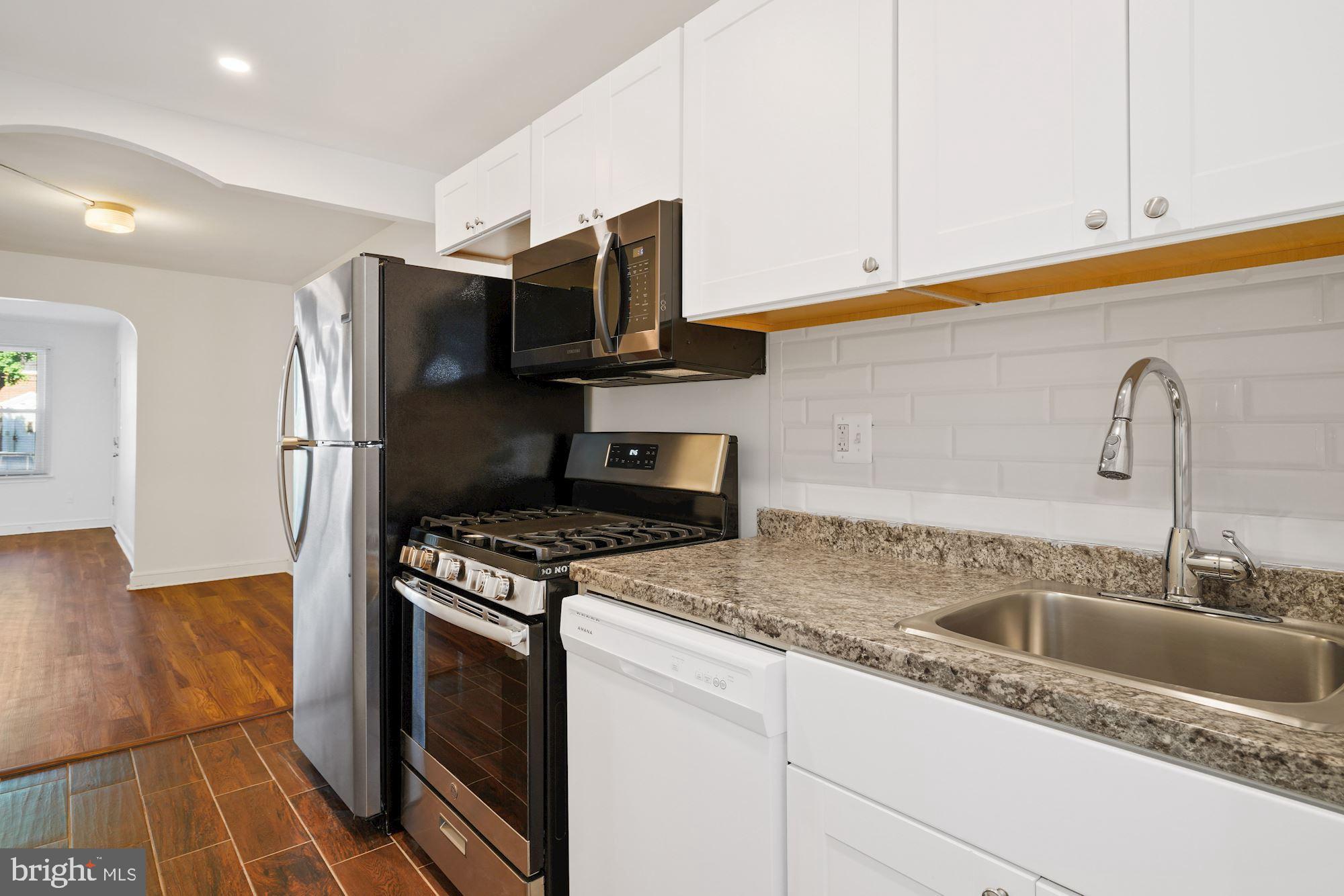 1612 17th Place Southeast Washington, DC 20020 - Photo 15 of 35 a kitchen with stainless steel appliances granite countertop a sink stove and refrigerator