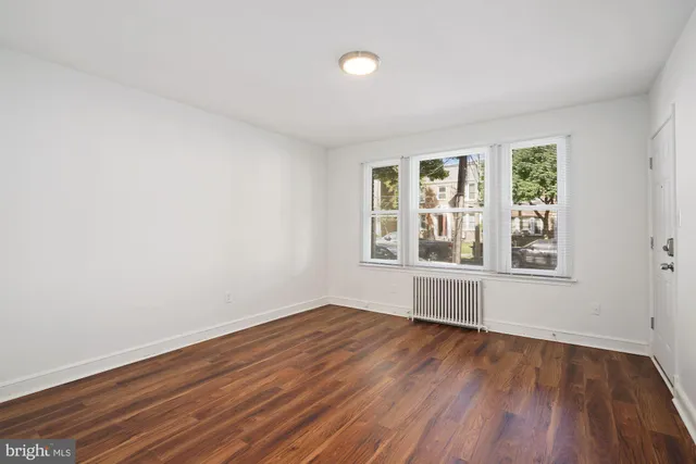 a view of a room with wooden floor and white walls