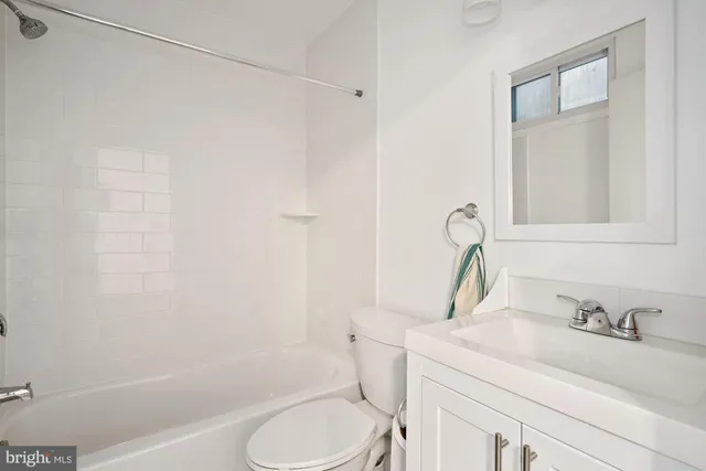 a view of an empty room with wooden floor and closet