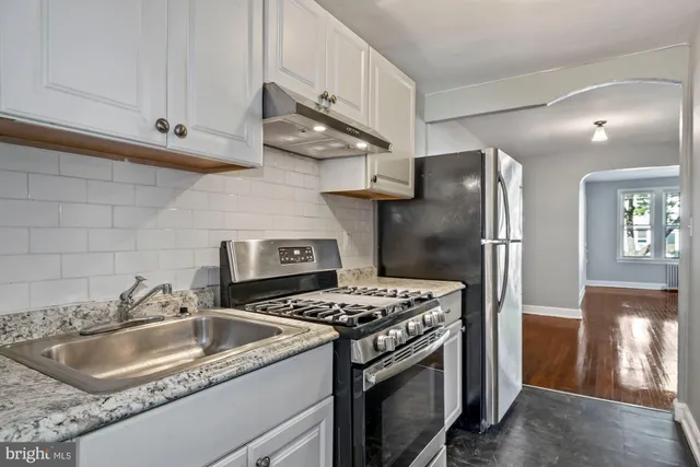 a kitchen with stainless steel appliances granite countertop a stove and a wooden cabinets