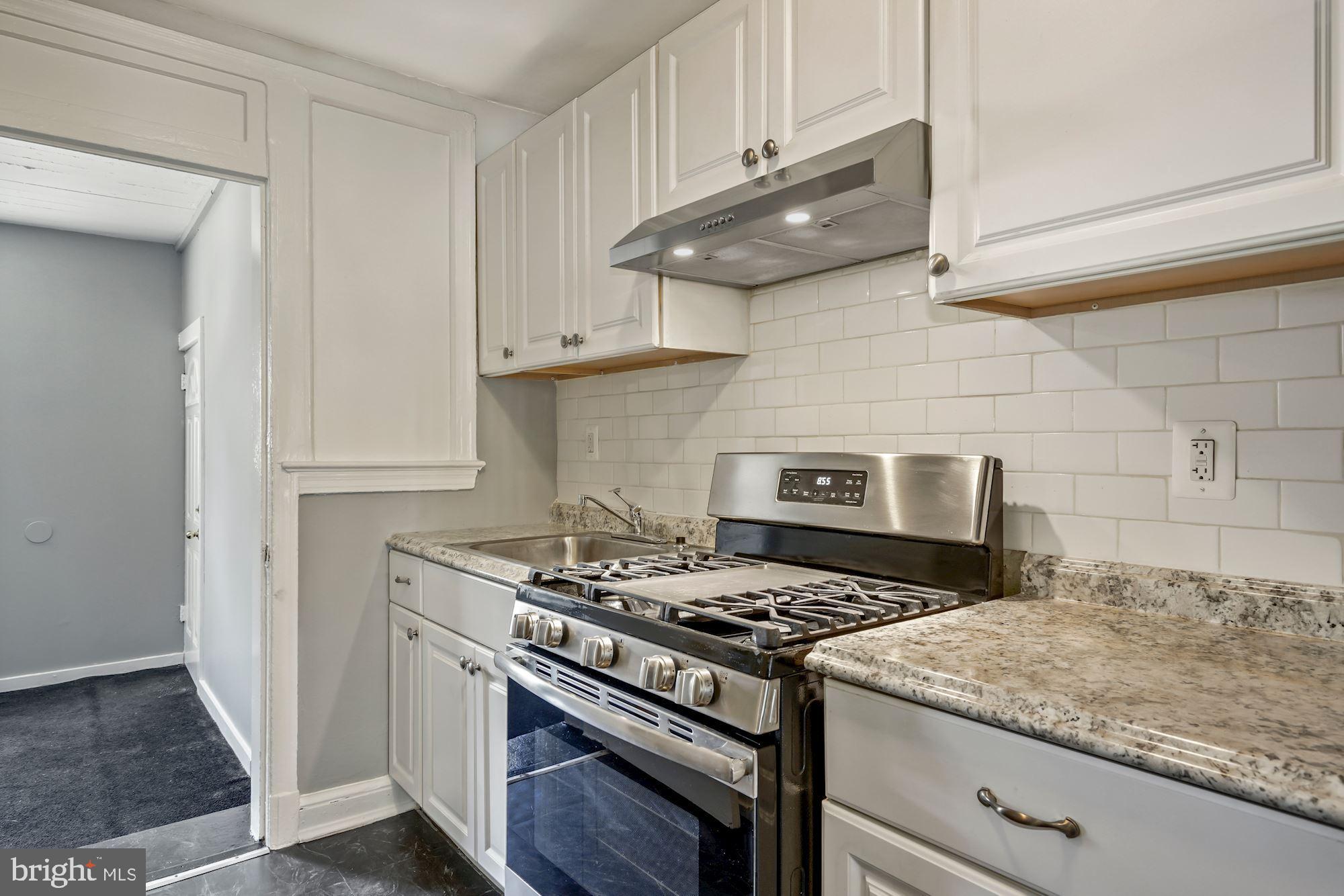 1612 17th Place Southeast Washington, DC 20020 - Photo 24 of 35 a kitchen with stainless steel appliances granite countertop a stove and a wooden cabinets