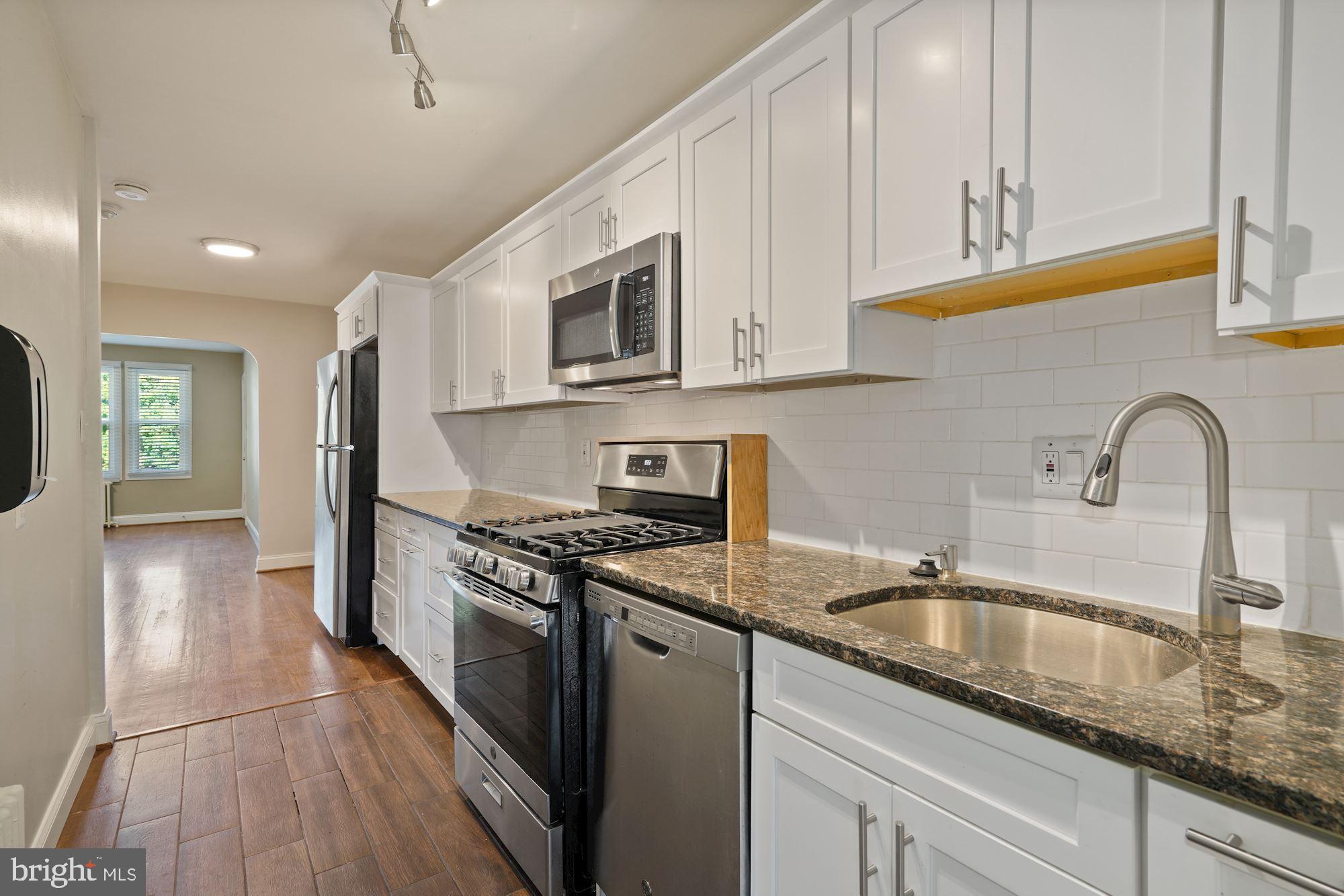 1612 17th Place Southeast Washington, DC 20020 - Photo 6 of 35 a kitchen with stainless steel appliances granite countertop a sink a stove and a wooden cabinets