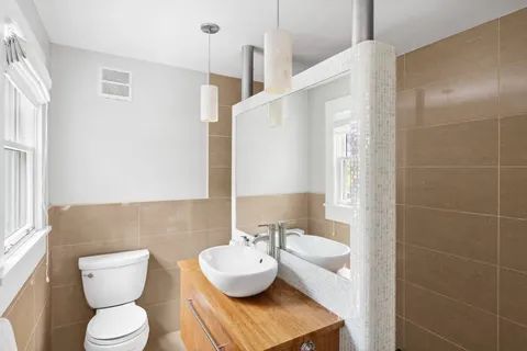 a bathroom with a toilet sink and mirror