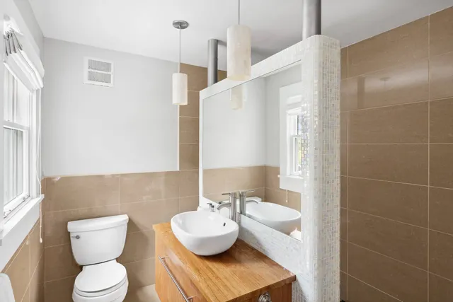 a bathroom with a toilet sink and mirror