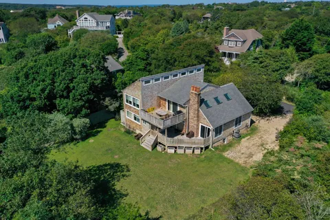 an aerial view of residential house with outdoor space and trees all around