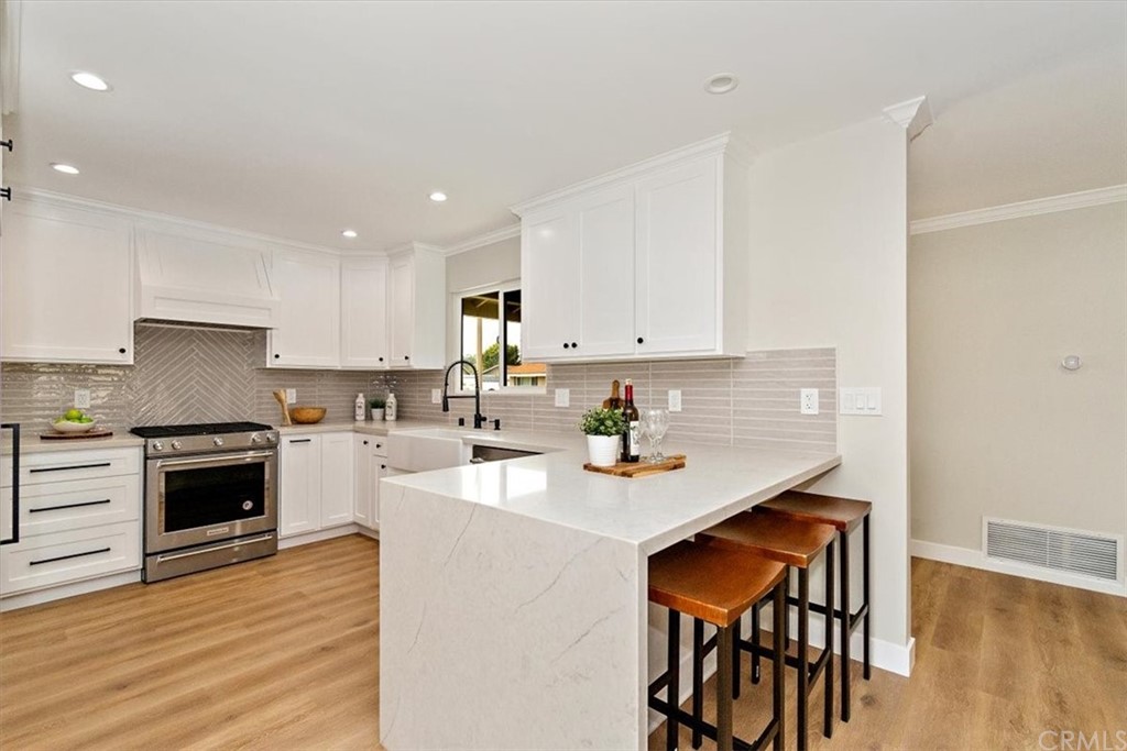 14101 Cameron Lane North Tustin, CA 92705 - Photo 11 of 36 a kitchen with kitchen island a dining table chairs cabinets and stainless steel appliances
