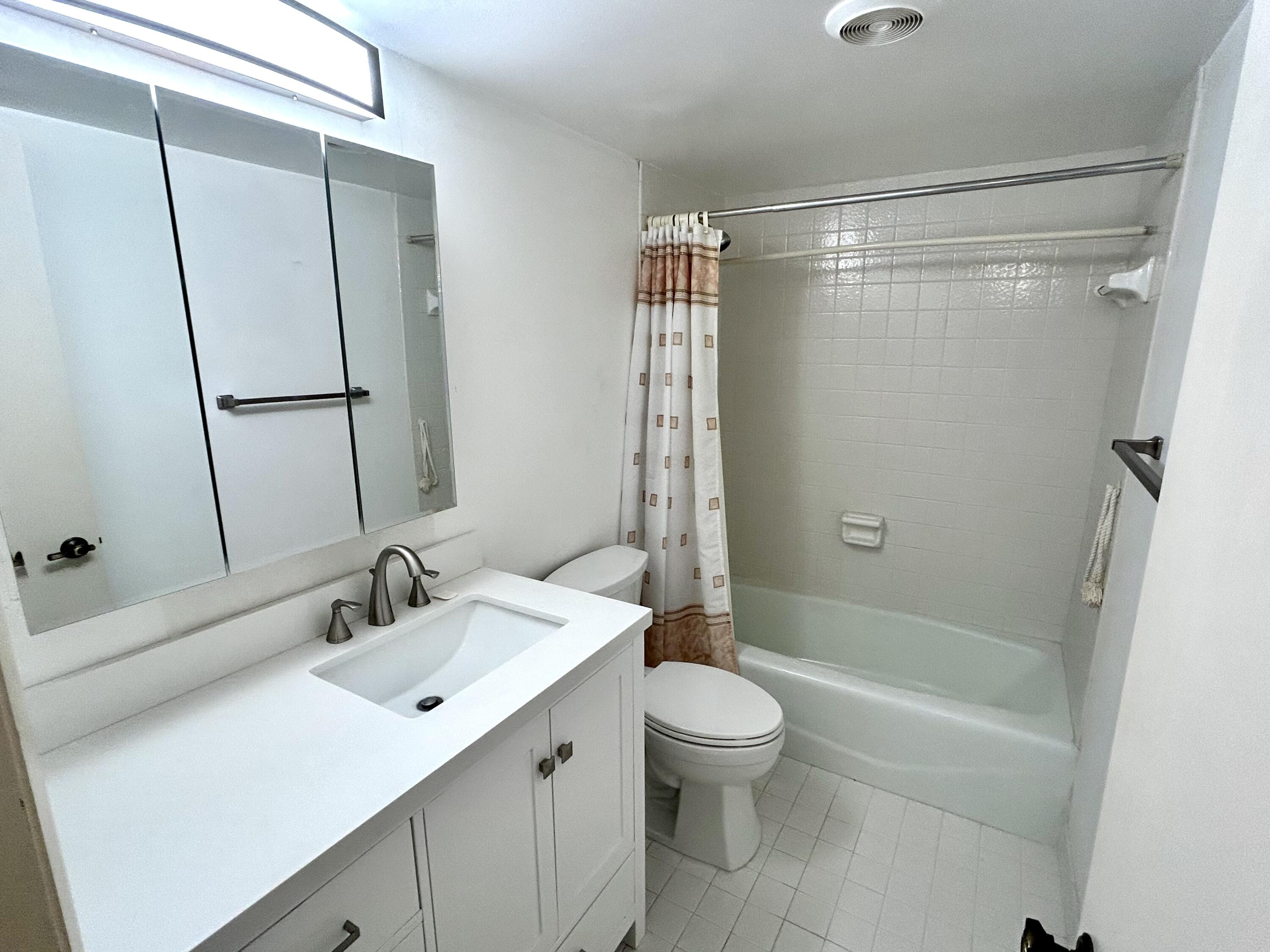 3930 Inverrary Boulevard, Unit 303D Lauderhill, FL 33319 - Photo 14 of 28 a bathroom with a sink toilet and shower