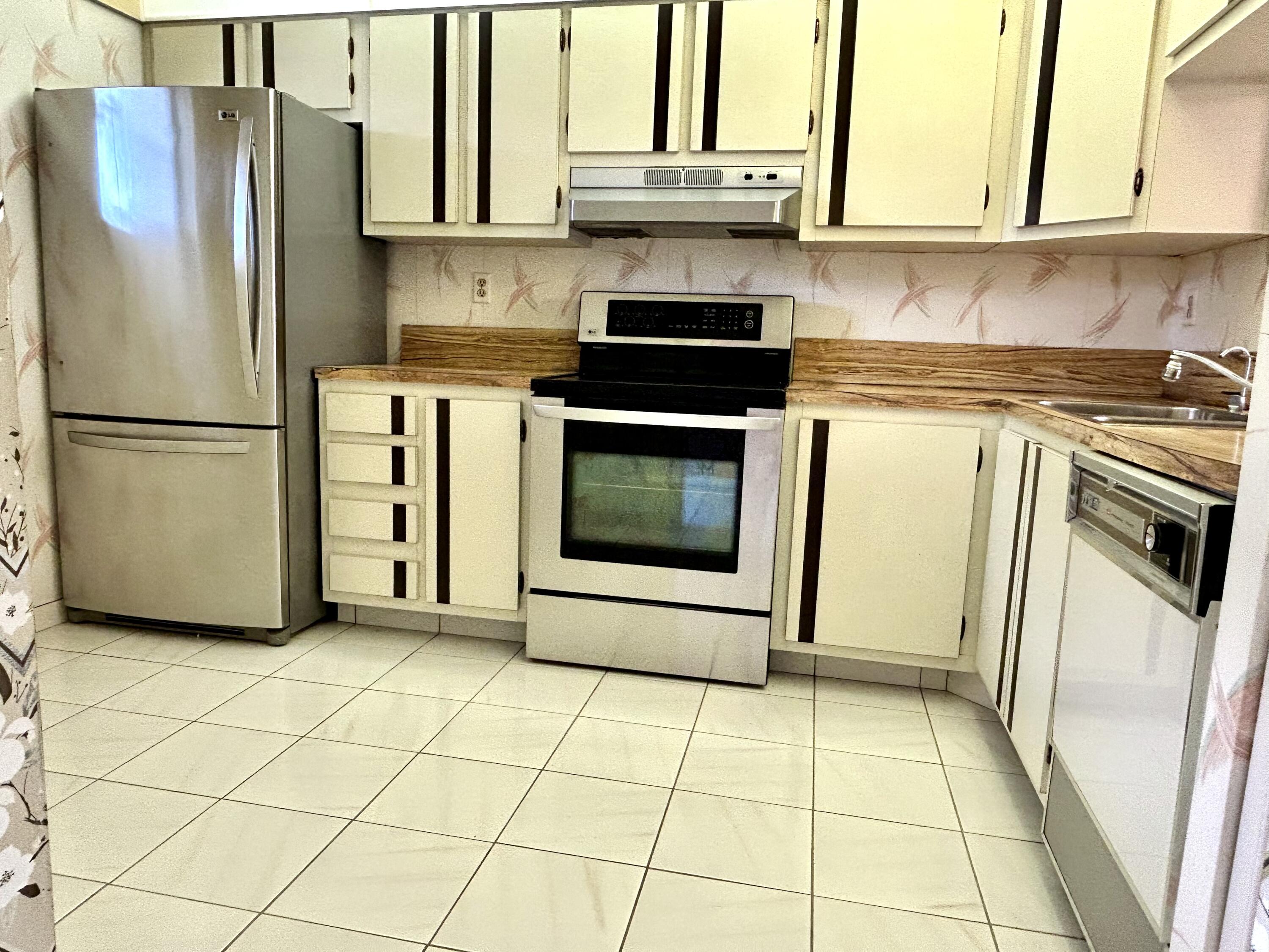 3930 Inverrary Boulevard, Unit 303D Lauderhill, FL 33319 - Photo 15 of 28 a kitchen with stainless steel appliances granite countertop a refrigerator sink and stove