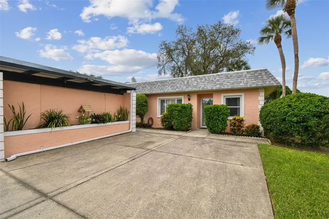 a view of a house with a yard and potted plants