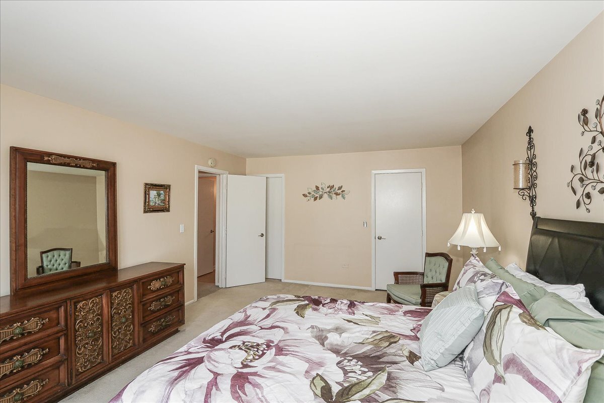 247 Nantucket Harbor Schaumburg, IL 60193 - Photo 12 of 25 a bedroom with a bed and a mirror on dresser