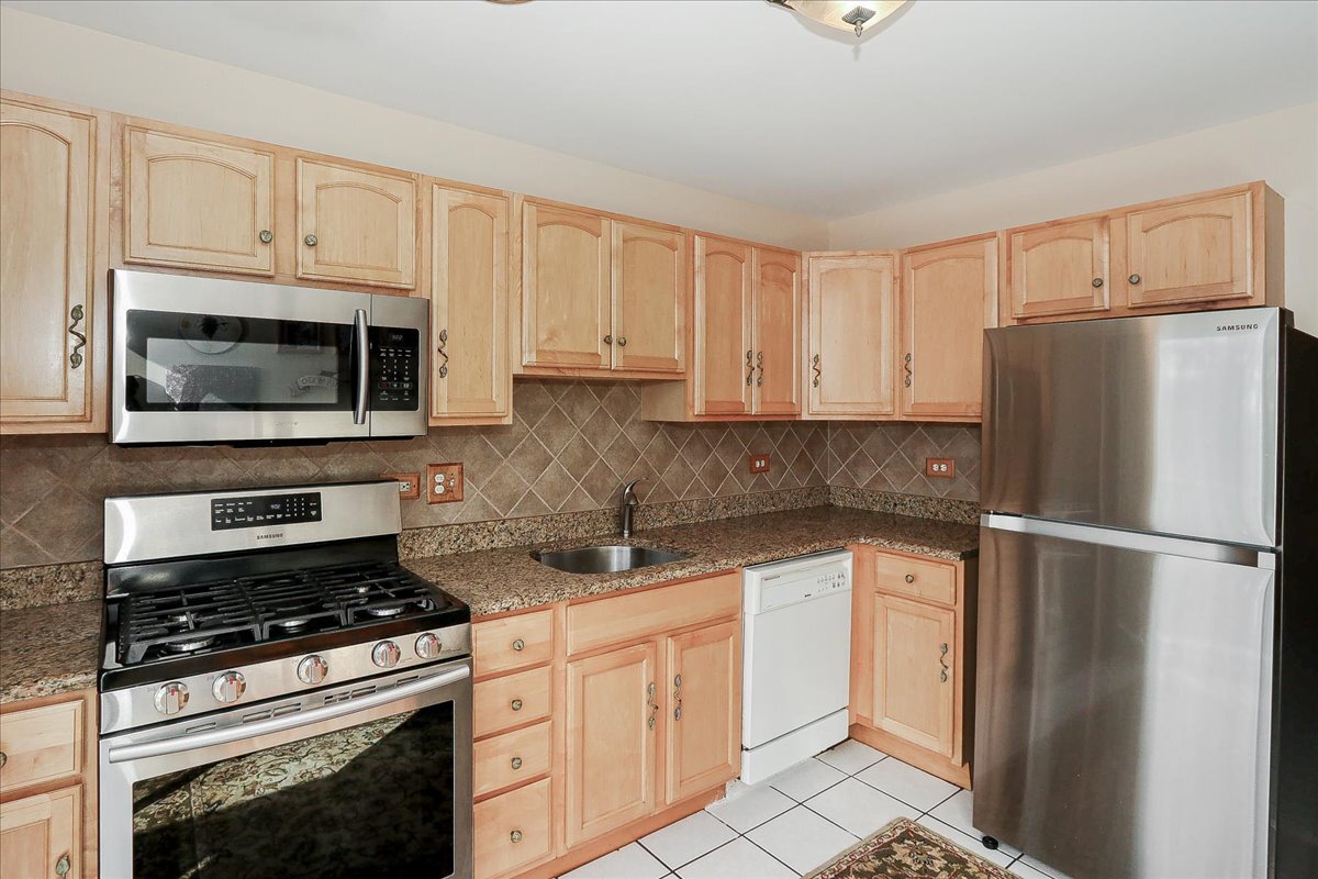 247 Nantucket Harbor Schaumburg, IL 60193 - Photo 8 of 25 a kitchen with white cabinets and stainless steel appliances