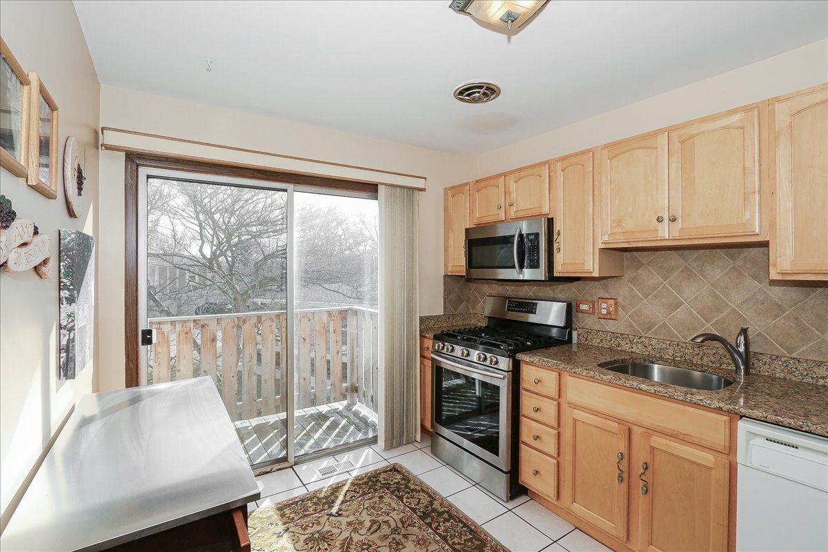 247 Nantucket Harbor Schaumburg, IL 60193 - Photo 9 of 25 a kitchen with granite countertop a stove a sink and a microwave