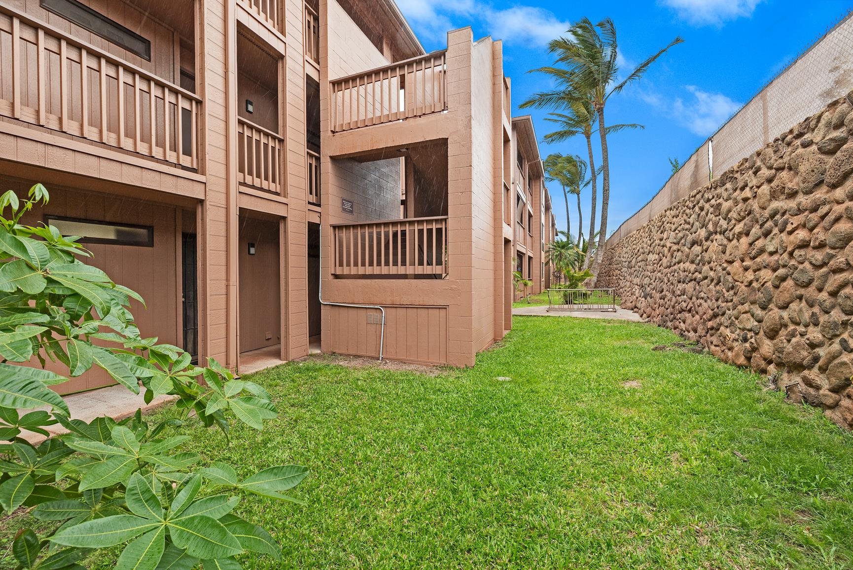 3740 Lower Honoapiilani Road, Unit G108 Lahaina, HI 96761 - Photo 2 of 24 a view of a brick house with a yard and a flower plants