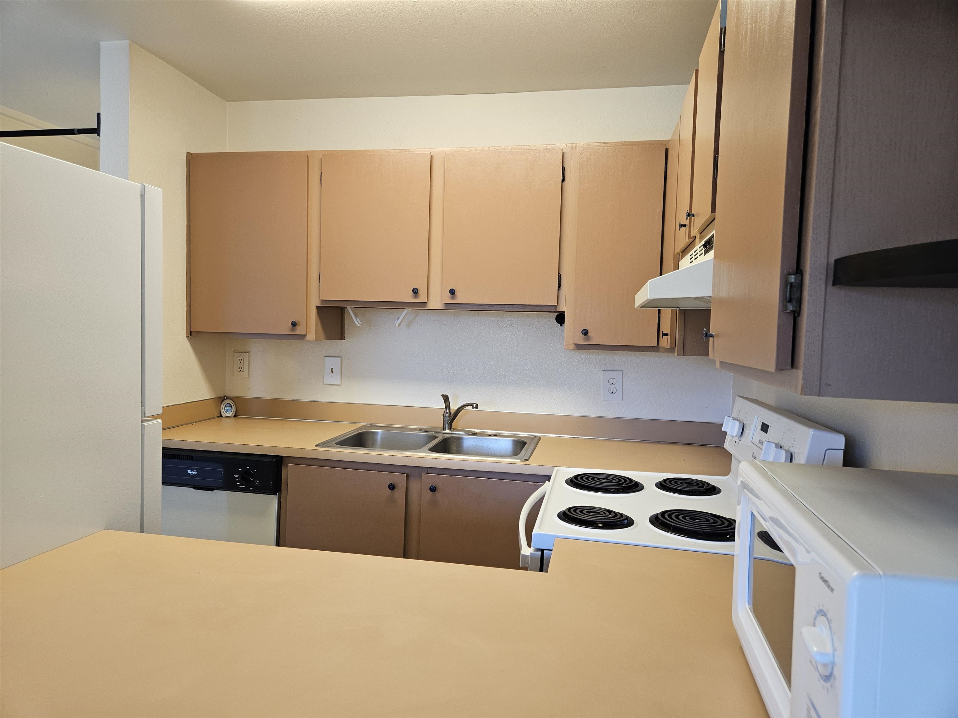 3740 Lower Honoapiilani Road, Unit G108 Lahaina, HI 96761 - Photo 9 of 24 a kitchen with a sink a stove and a refrigerator