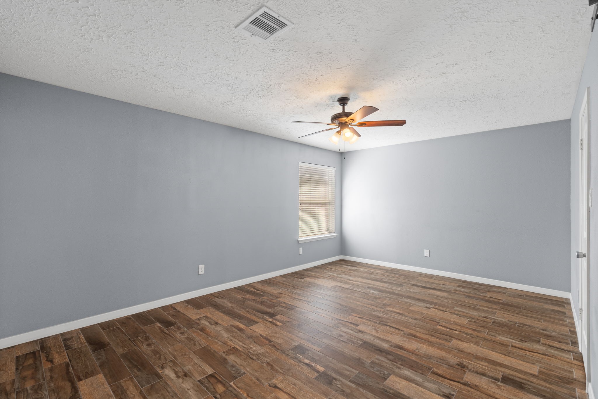 2622 Strait Lane Houston, TX 77084 - Photo 20 of 47 a view of an empty room with chandelier fan and wooden floor