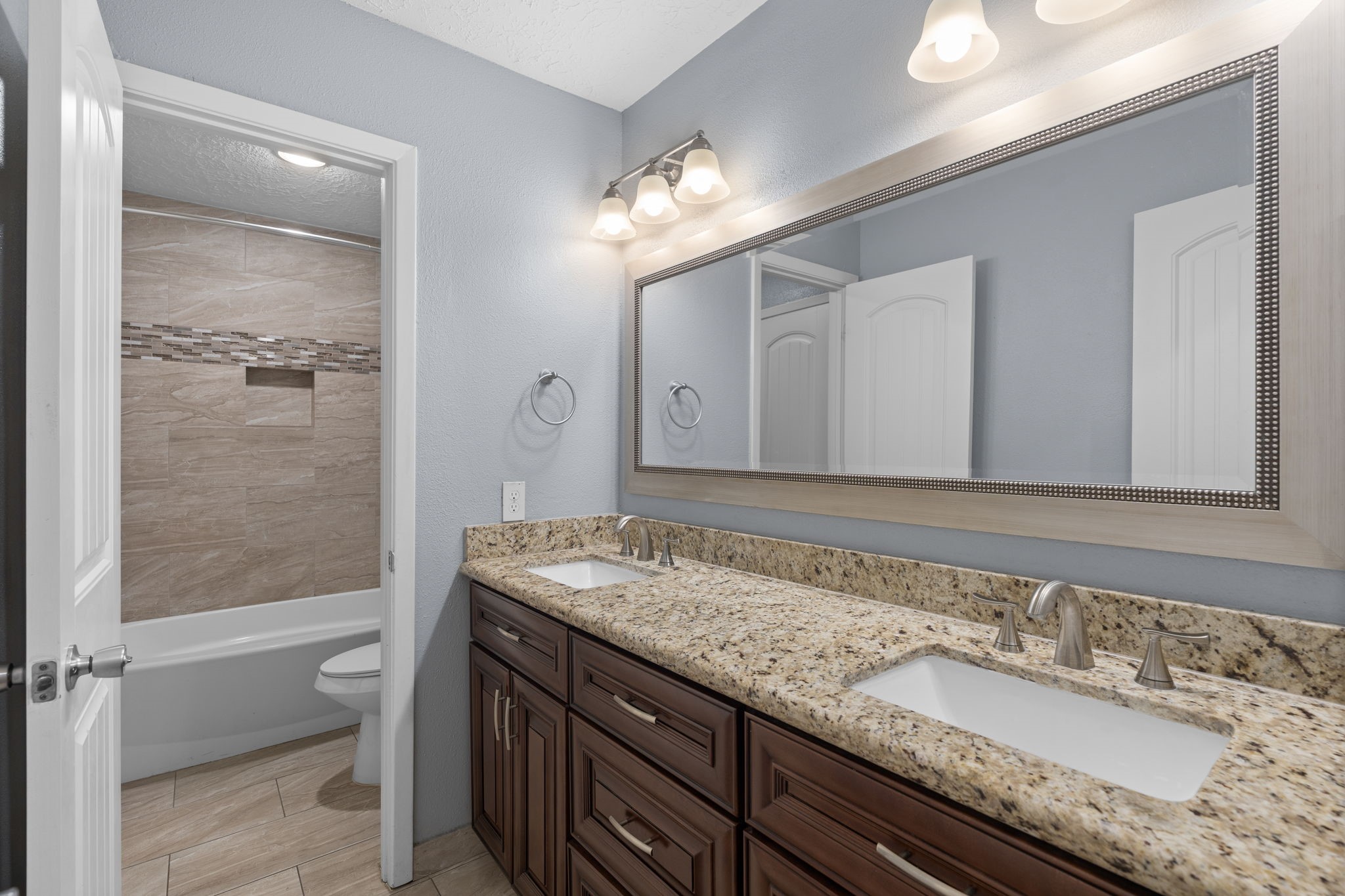2622 Strait Lane Houston, TX 77084 - Photo 29 of 47 a bathroom with a granite countertop sink a toilet and a mirror