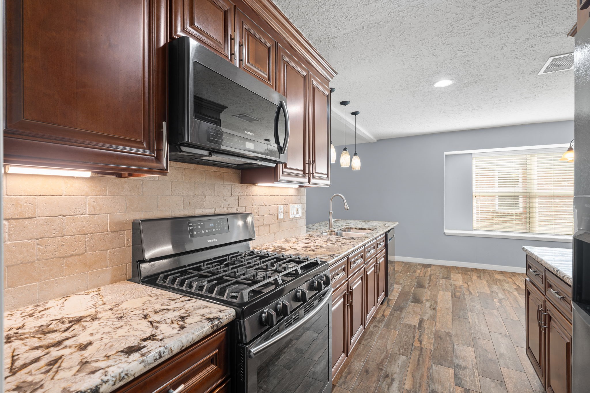2622 Strait Lane Houston, TX 77084 - Photo 10 of 47 a kitchen with granite countertop a stove and a microwave