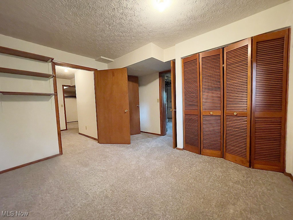 2285 Killian Road Akron, OH 44312 - Photo 11 of 32 Unfurnished bedroom with a textured ceiling, light colored carpet, and a closet