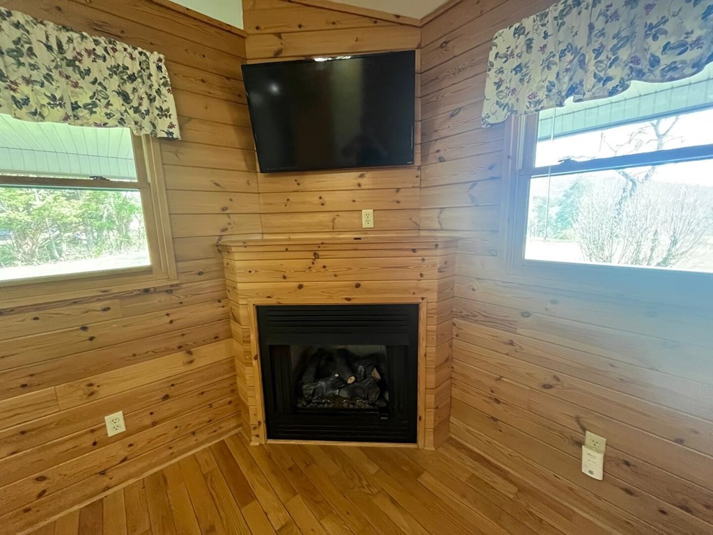 142 Arrowhead Trail Hayesville, NC 28904 - Photo 5 of 41 a living room with a fireplace and a flat screen tv