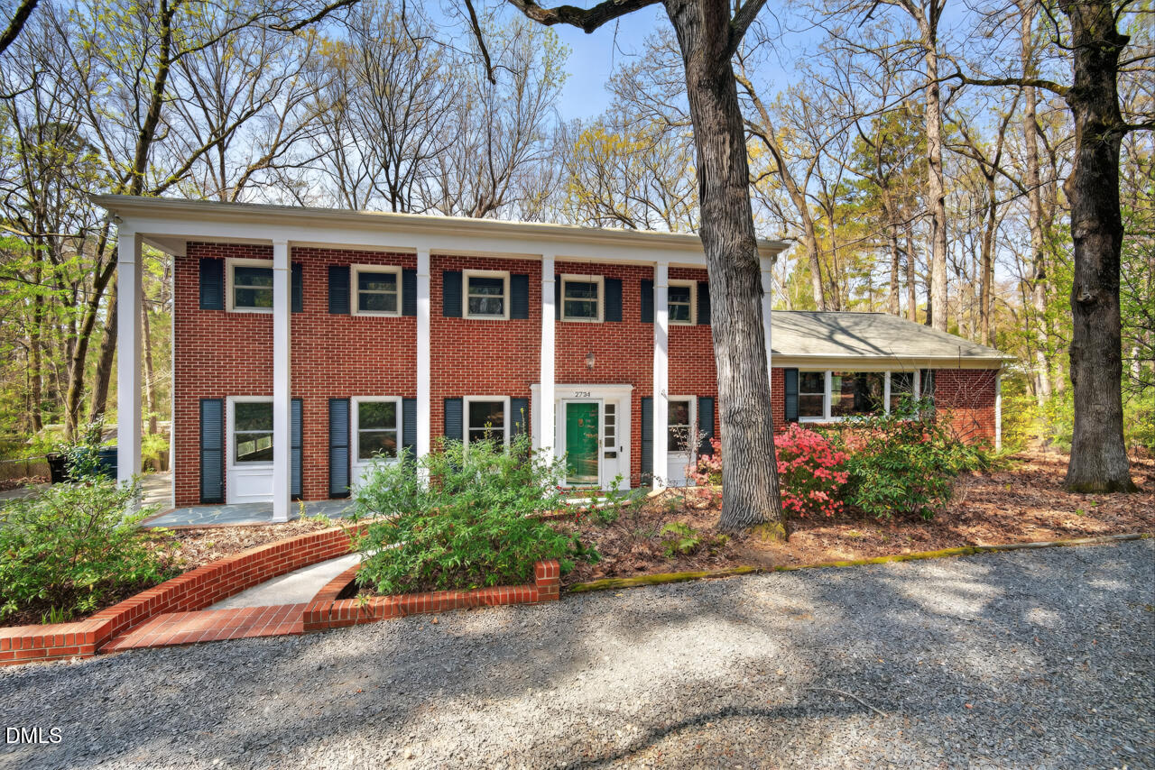 front view of a brick house with a yard
