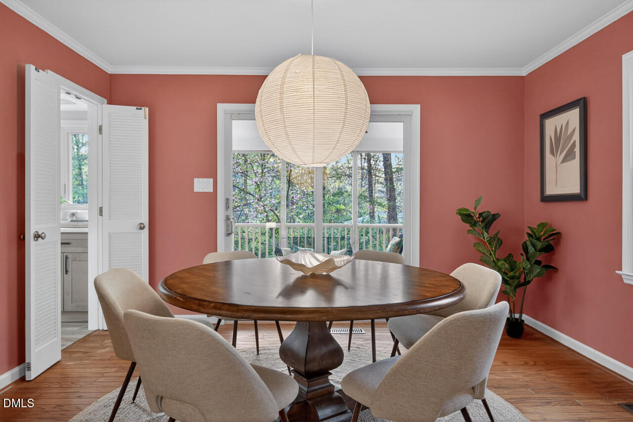 2734 Spencer Street Durham, NC 27705 - Photo 17 of 61 a dining room with furniture a potted plant and wooden floor