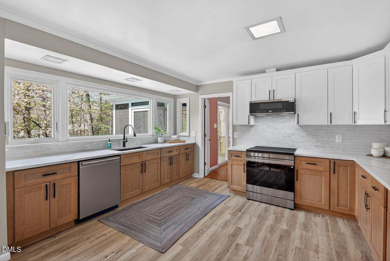 2734 Spencer Street Durham, NC 27705 - Photo 23 of 61 a large kitchen with stainless steel appliances granite countertop a stove and a sink