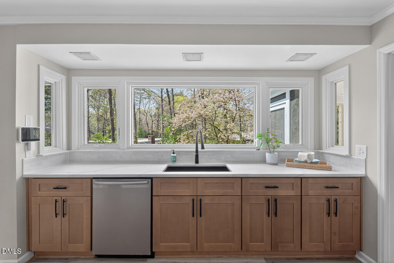 2734 Spencer Street Durham, NC 27705 - Photo 26 of 61 a kitchen with white cabinets and a large window