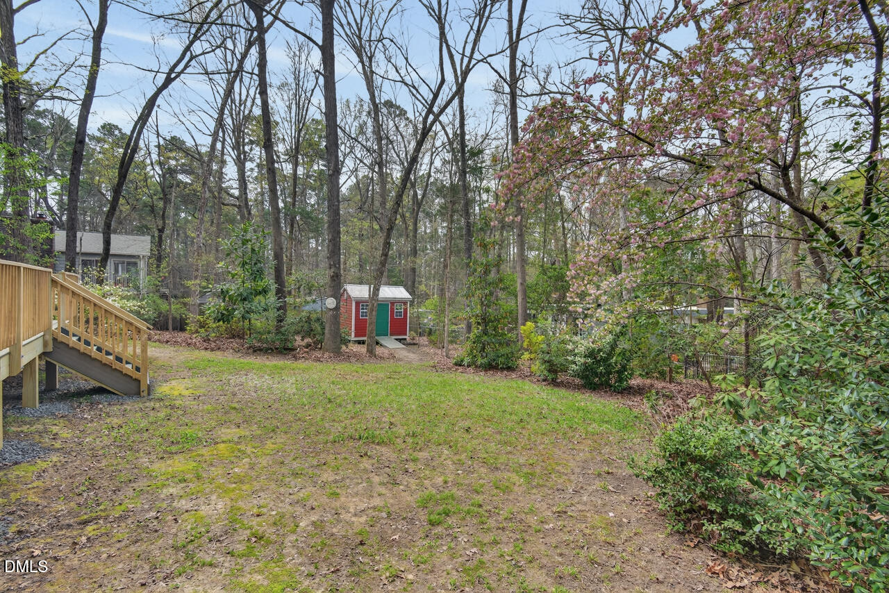 2734 Spencer Street Durham, NC 27705 - Photo 54 of 61 a backyard of a house with trees and wooden fence