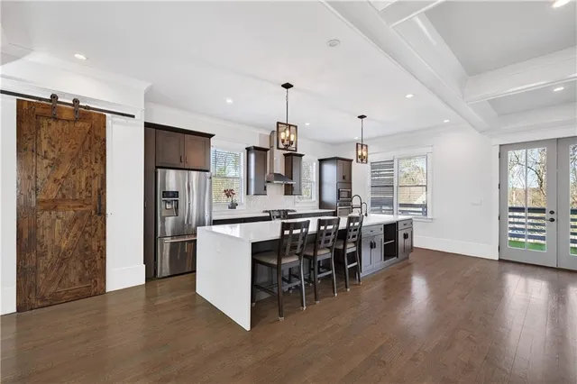 a kitchen with stainless steel appliances kitchen island granite countertop a table chairs and a chandelier