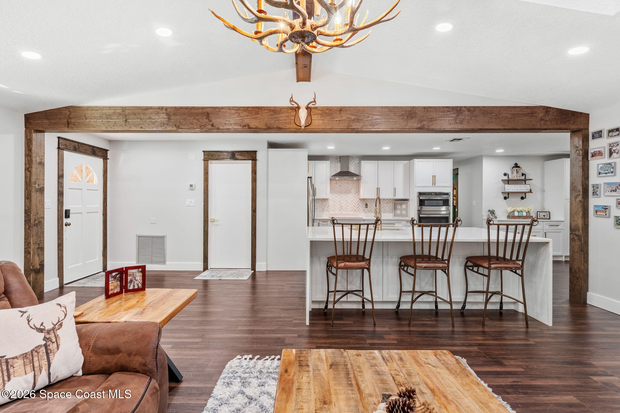 3975 Corey Road Malabar, FL 32950 - Photo 15 of 53 a living room with furniture a wooden floor and a chandelier