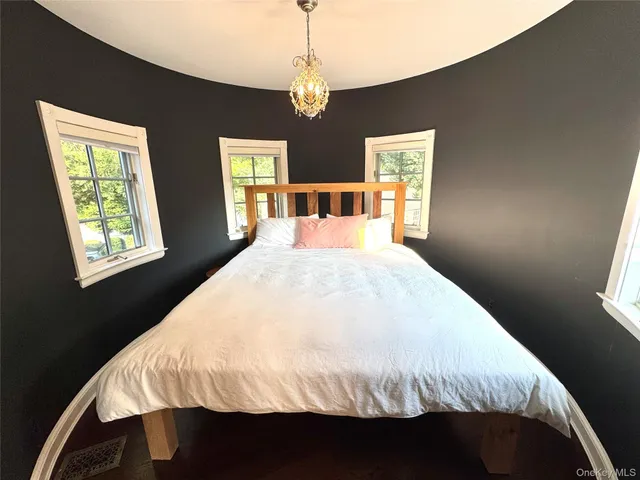 a large bed in a bedroom next to a window