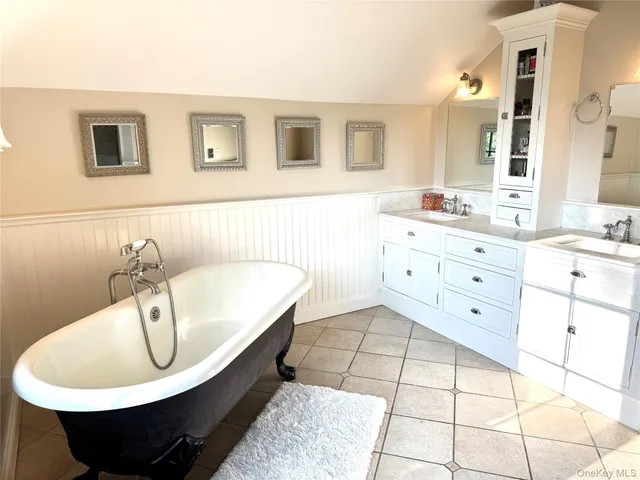 a bathroom with a sink a bathtub and a mirror