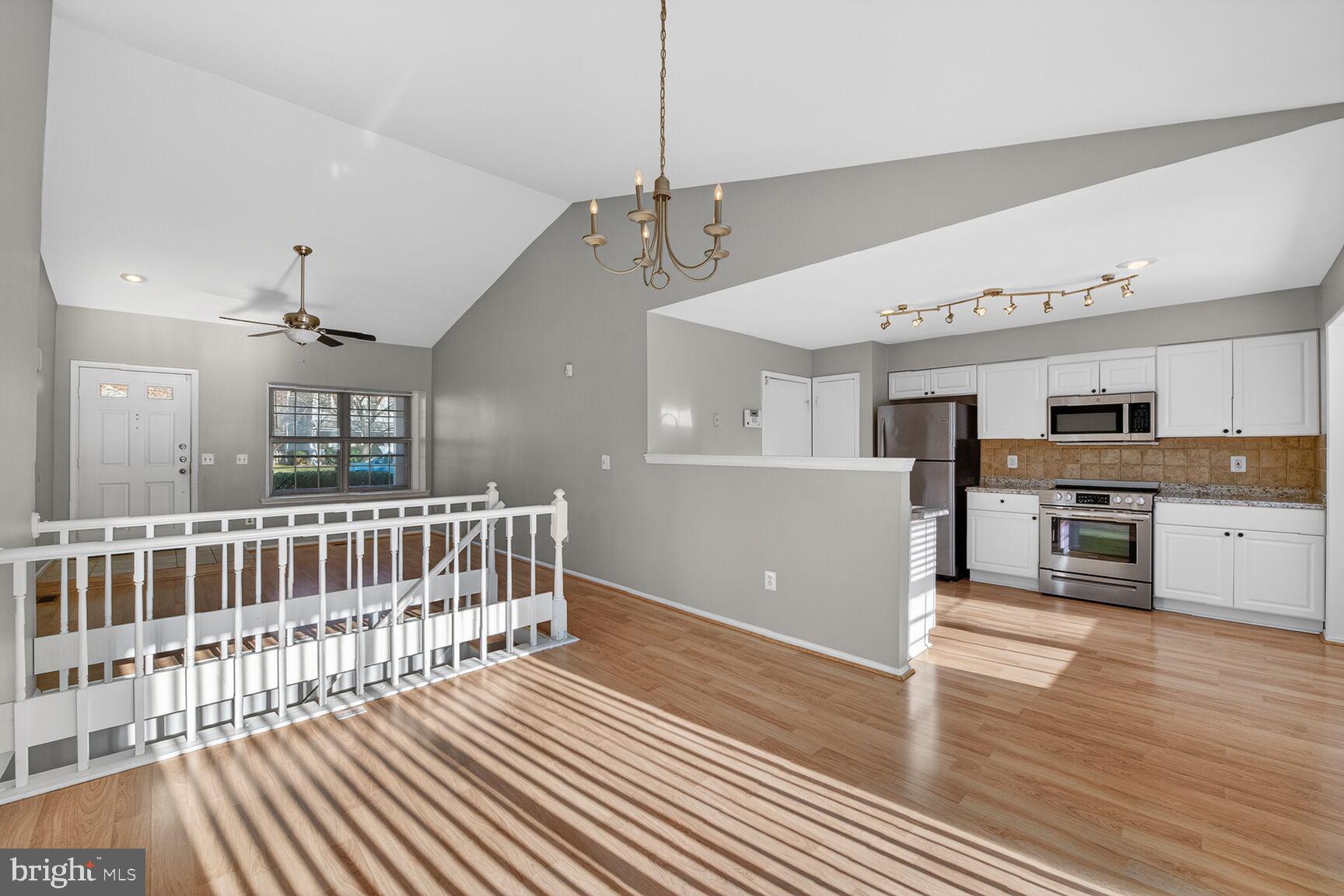 14 Braxton Drive Sterling, VA 20165 - Photo 5 of 28 a open kitchen with stainless steel appliances granite countertop a refrigerator oven a sink dishwasher and white cabinets with wooden floor