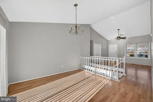 a view of a hallway with wooden floor and windows