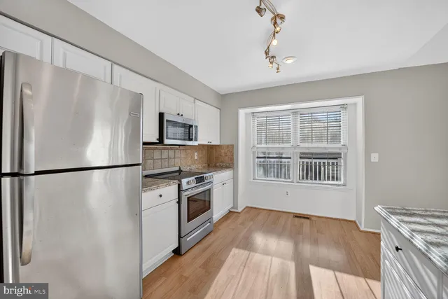 a kitchen with stainless steel appliances a refrigerator stove and microwave