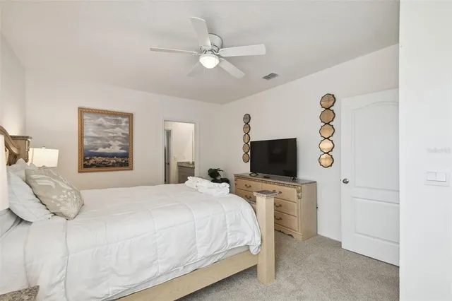 a bedroom with a bed and a flat tv screen on dresser