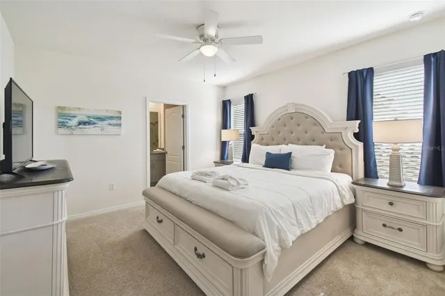 a bedroom with a large bed and a ceiling fan