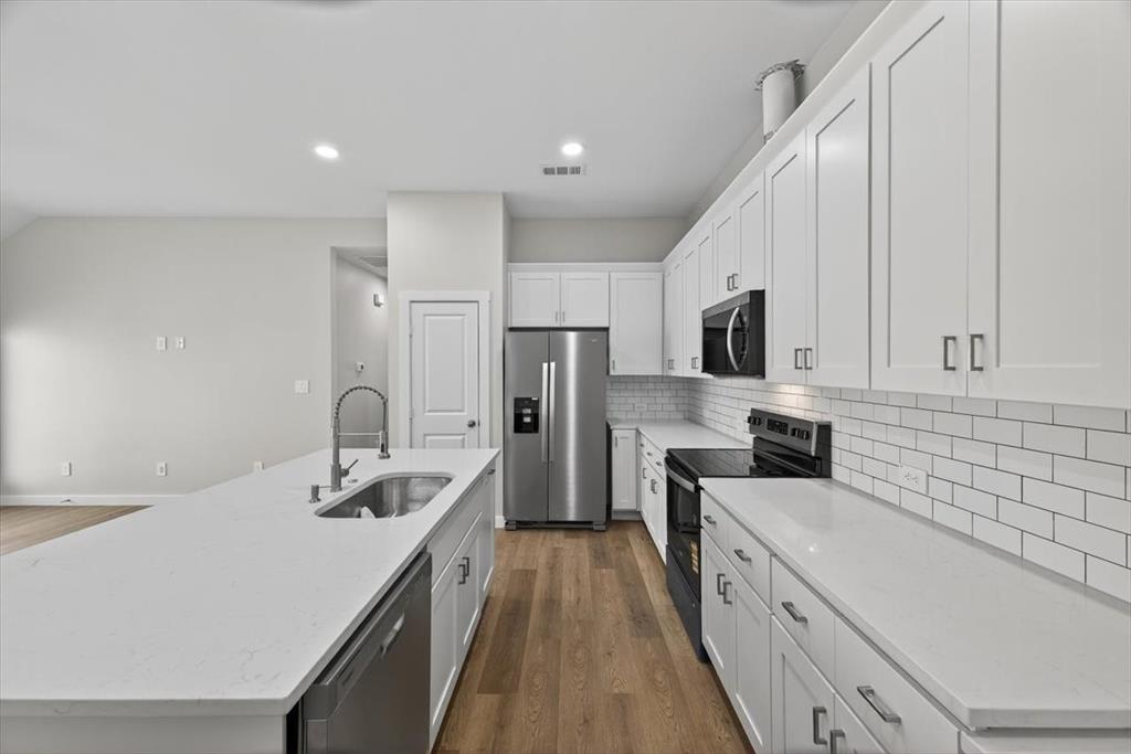 122 Wood Street, Unit A Princeton, TX 75407 - Photo 11 of 29 a kitchen with a sink a counter top space stainless steel appliances and cabinets