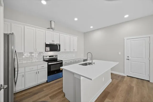 a kitchen with stainless steel appliances a refrigerator sink and microwave