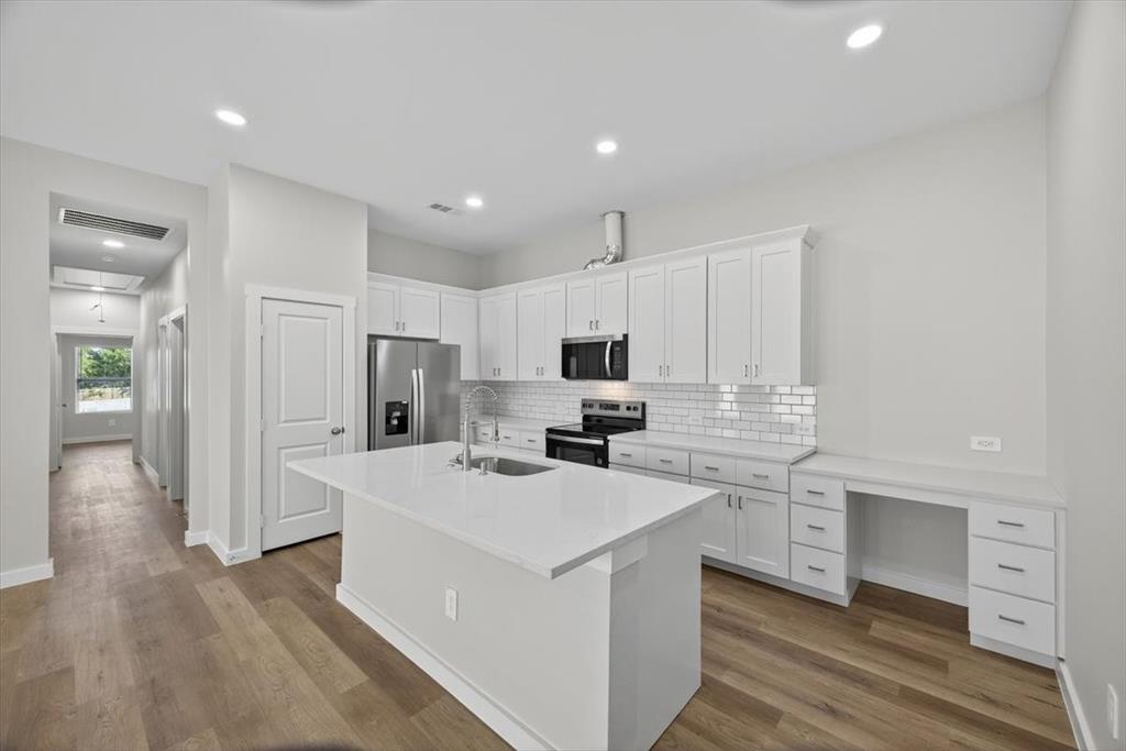 122 Wood Street, Unit A Princeton, TX 75407 - Photo 10 of 29 a kitchen with white cabinets and stainless steel appliances