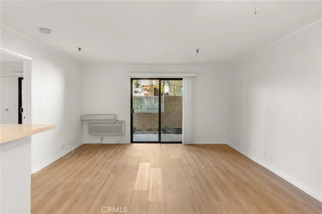 a view of a room with wooden floor and a window