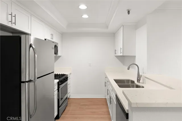 a kitchen with stainless steel appliances a refrigerator a sink a stove a microwave and cabinets